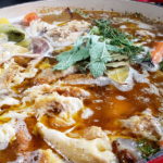 Chicken bones, water and herbs added to pan