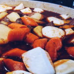 Picture of root vegetables added to pot of stew.