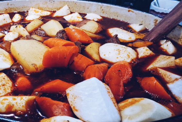 Picture of root vegetables added to pot of stew.